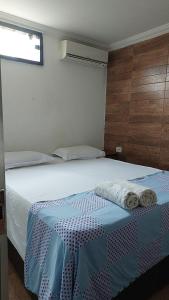欧纳波利斯Casa de amigos e parentes的一间卧室配有一张床,上面有两条毛巾