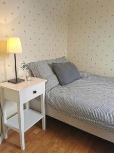 卡尔马Gästhus nära havet的一间卧室配有一张床和一个带灯的床头柜
