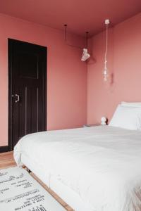 圣尼古拉Huis Hector Mechiels的卧室配有白色的床和粉红色的墙壁