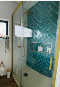 拉夫拉Casa Sol的带淋浴的浴室和蓝色瓷砖墙