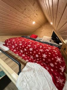 耶塞尼克Challet44的一张位于木制房间的床,配有红色毯子