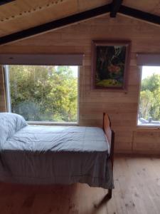 蒙特港Casa Aoni的卧室配有床,位于带2个窗户的房间