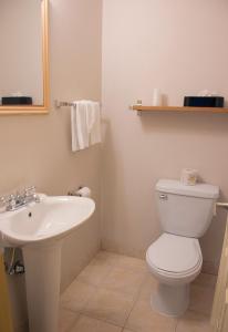 WestlockAll Stay Suites的浴室配有白色卫生间和盥洗盆。