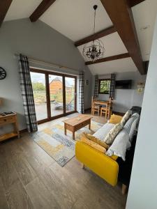 阿伦德尔Rife Lodges的客厅配有黄色的沙发和桌子