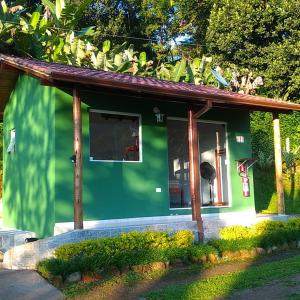 帕拉蒂Chalés Vale dos Pássaros的一座带大窗户的绿色小房子