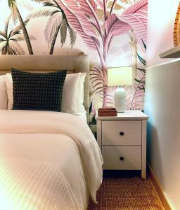 都柏林Blush Jungle的一间卧室配有一张床和一个带灯的床头柜