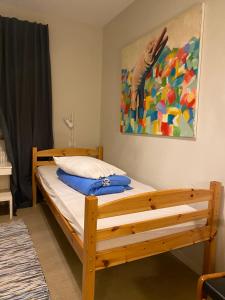 GunsjögårdenFristad Hostel Vitsand的一间卧室配有一张木床,墙上挂有绘画作品