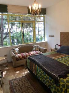 圣地亚哥Espacio Verde en Providencia的客房设有两张床、一张沙发和窗户。
