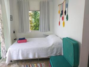韦尔卡鲍Morada dos Elfos的一间卧室配有一张床和一把绿色椅子