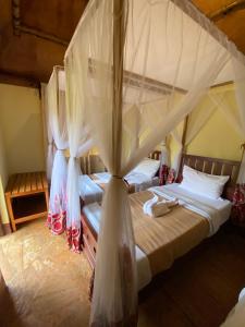 卡拉图Patamu Restaurant & Lodge的一间卧室配有两张床和蚊帐
