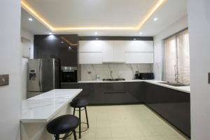 拉各斯Unit i2 City House (Sleeps 6)的厨房配有白色橱柜、黑色柜台和凳子