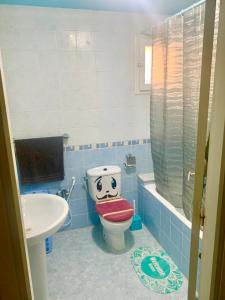 突尼斯Dream Appartement El Aouina的浴室设有卫生间,面部被画出来