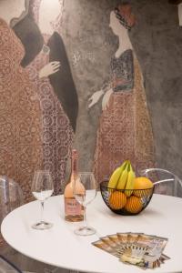 米兰莫斯科瓦豪华住宿加早餐旅馆的一张桌子,上面放着两杯葡萄酒和一碗香蕉