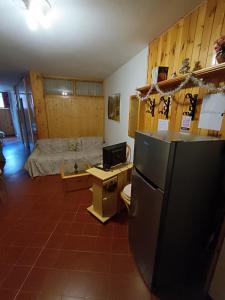 阿贝托内Le Marmotte - Appartamento的客房设有冰箱和床。