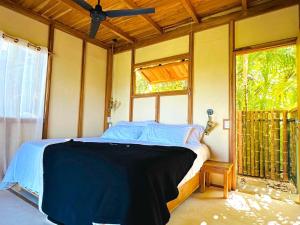圣塔特蕾莎海滩Calamocha Lodge的一间带床的卧室,位于带窗户的房间内