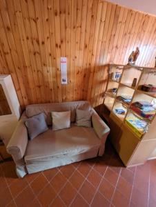 阿贝托内Le Marmotte - Appartamento的木墙的房间里一张沙发