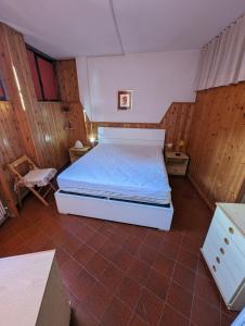 阿贝托内Le Marmotte - Appartamento的卧室配有一张床铺,位于带木墙的房间内