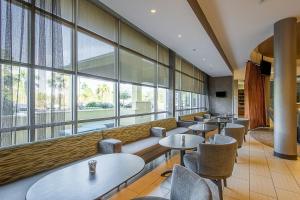 坦帕坦帕棕榈/北坦帕春季山丘套房酒店的餐厅设有桌椅和大窗户。