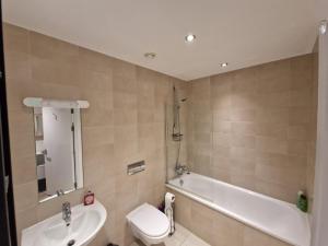 谢菲尔德Luxury Modern Apartment Stay的一间带水槽、浴缸和卫生间的浴室