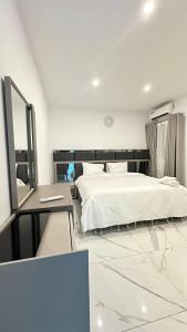 阿比让Residence Roume Abidjan Plateau的卧室配有白色的床和镜子