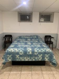 萨格奈La Maison Tanguay的一间卧室配有一张带蓝色和白色被子的床