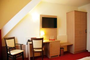 绍尔滕斯慕尼奈克酒店的客房设有带椅子的书桌和电视。