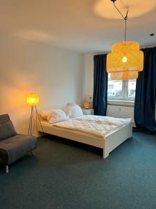 班贝格4rooms - Bamberger Gemütlichkeit的一间卧室配有一张床、一盏灯和一把椅子