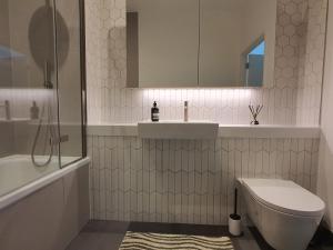 伦敦Cozy Room with Private Bathroom in Luxurious Flat的浴室配有卫生间、盥洗盆和浴缸。