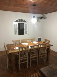 布希奥斯Casa de Família com Ar Condicionado, Garagem e Pet friendly的一间带木桌和椅子的用餐室