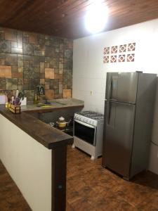布希奥斯Casa de Família com Ar Condicionado, Garagem e Pet friendly的厨房配有不锈钢冰箱和炉灶。