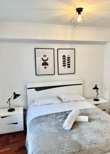 布拉干萨Cantinho do Castelo的一间卧室配有一张带两盏灯的大型白色床。