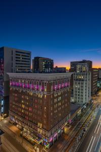 凤凰城Moxy Phoenix Downtown的一座粉红色灯的建筑