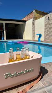 里韦拉Casa con piscina y barbacoa的游泳池旁的浴缸里备有4瓶啤酒