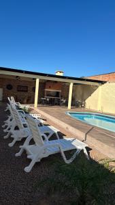 里韦拉Casa con piscina y barbacoa的游泳池旁的一排白色躺椅