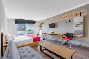埃莫西约埃莫西约城市通酒店的配有一张床和一张书桌的酒店客房