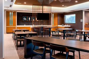 兰奥莱克斯SpringHill Suites by Marriott Tampa Suncoast Parkway的餐厅设有桌椅和平面电视。