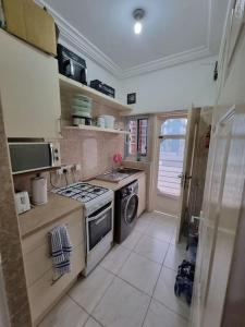Kwabenyan2 bedrooms Apartment, Hillview of Accra的厨房配有炉灶和洗衣机。
