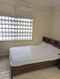 Kwabenyan2 bedrooms Apartment, Hillview of Accra的窗户客房内的一张床位
