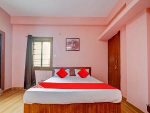 博帕尔Hotel Crown Square的一间卧室配有一张带红色枕头的大床