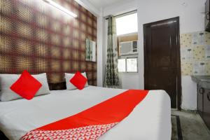 古尔冈OYO Flagship Corporate House的一间卧室配有一张带红色枕头的大床