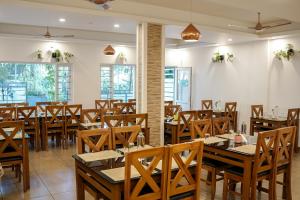 蒙纳Munnar Ice Queen Resorts的用餐室配有木桌和椅子