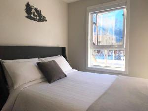 坎莫尔Mountain Retreat: Brand New 2BR Condo的卧室配有白色的床和窗户