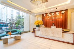 岘港May Beach Hotel的站在大厅的女人可能破酒店