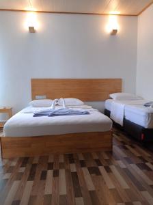 弗里德胡Fulidhoo Hathaa Retreat的铺有木地板的客房内的两张床