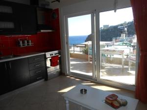 ParánimfoiAmazing Beachside Apartment With Panoramic Seaview的厨房通过滑动玻璃门可欣赏到海景