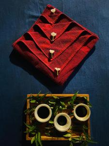 锡吉里亚Prana Ayurveda Chalet- Sigiriya的红色餐巾上装有三环的木托盘