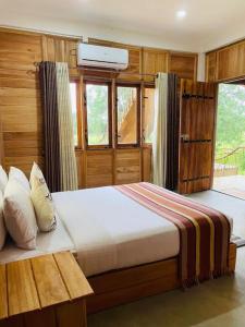 锡吉里亚Prana Ayurveda Chalet- Sigiriya的一间卧室设有一张大床和一个窗户。