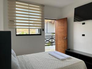 维加伊托Riviera Vichayito的一间卧室设有一张床和一个带电视的窗户。