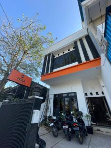 库塔Fora Capsule Hostel Tuban Kuta Bali的停在大楼前的两辆摩托车