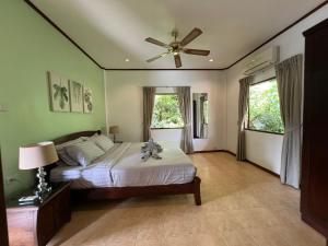 涛岛Woodlawn Villas Resort的一间卧室配有一张床和吊扇